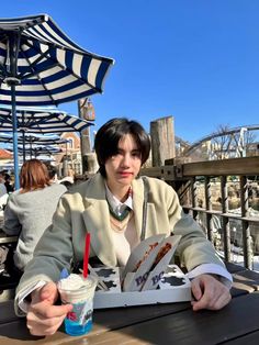 a person sitting at a table with an umbrella