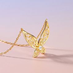 This enchanting golden sterling silver necklace, inspired by the ethereal grace of elf wings. The pendant mesmerizes with intricate hollow patterns, evoking a sense of intelligence and vivacity. At its heart lies a round stone, radiating purity and light. It's a tribute to the beauty of fantasy and the elegance of nature. Wear it as a symbol of your own inner magic, and let it captivate all who behold its charm.Carat Weight: 0.18 ctStone Size: 3 mmStone Type: Jeulia® StoneNumber of Stones: 1 Sto Gold Pendant Fantasy Necklace, Gold Fantasy Pendant Jewelry, Gold Fantasy Pendant Necklace, Gold Pendant Necklace In Fantasy Style, Elf Wings, Wings Design, Round Necklace, Necklace Online, White Stone