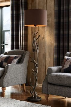 a living room scene with focus on the floor lamp and chair next to the window