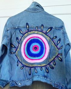 This is a hand painted one of a kind designs.  Acrylic paint on denim, Evil Eye with pinks, blues and gold and glitter accents.  This design can be painted on a different size jacket.  Please allow an extra week processing time for this request. Artistic Hand Painted Blue Denim Jacket, Hand-painted Blue Denim Jacket, Blue Hand Painted Denim Jacket, Hand Painted Blue Denim Jacket With Long Sleeves, Hand Painted Blue Long Sleeve Denim Jacket, Hand Painted Long Sleeve Blue Denim Jacket, Hand Painted Blue Denim Jacket, Paint On Denim, Hand Painted Denim