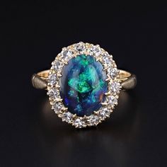 Vintage Black Opal Ring: This Art Deco ring (circa 1920-1930) features a stunning black opal set in a halo of single cut diamonds set in 18k gold. The black opal weighs approximately 2.05ct and the combined weight of the diamonds weighs 0.75ct. The face of the ring measures 0.6 inches from top to bottom by 0.5 inches wide, and it is in great condition.  The ring is a size 6.25, but it can be resized free of charge. The ring weighs 3.82 grams.  Upon purchase, your ring will arrive elegantly packa Luxury Black Opal Ring Elegant Style, Art Deco Opal Ring, Black Oval Opal Ring For Formal Occasions, Elegant Formal Opal Ring With Halo Design, Classic Opal Ring With Halo Setting For Formal Occasions, Formal Opal Ring With Halo Setting, Formal Opal Diamond Ring With Halo Design, Formal Fine Jewelry Opal Ring With Halo Design, Formal Opal Halo Ring