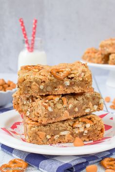 three pieces of granola bars stacked on top of each other with milk in the background