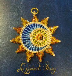 a blue and yellow brooch with gold accents