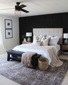 a bedroom with black walls, white bedding and gray carpeted area rugs