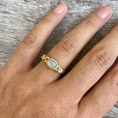 Choose between these gorgeous polished Ethiopian opal rings with amazing sparkles set in sterling silver and then gold plated. The ring has a little different faceted tourmaline on each side of the main stone. Choose between: Blue and yellow- N 1/2 (UK/AU size ring) 6 3/4 (US size) Green and brown- L 1/2 (UK/AU size ring) 5 7/8 (US size) Blue and pink- N 1/2 (UK/AU size ring) 6 3/4 (US size) Pink and brown- M 1/2 (UK/AU size ring) 6 1/4 (US size) This ring would make the most perfect bridesmaid' Gold Three Stone Stackable Rings As Gift, Elegant Gold Stackable Rings With Gemstone Accents, Dainty Sterling Silver Rings With Gemstone Accents, Gold Ethiopian Opal Ring For Anniversary, Dainty Topaz Jewelry For Wedding, Dainty Topaz Wedding Jewelry, Gold Opal Ring In Sterling Silver, Gold Sterling Silver Birthstone Ring With Gemstone Accents, Gold Topaz Ring With Gemstone Accents In Sterling Silver