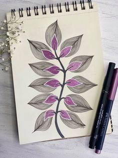 a drawing of a flower on a notebook next to some markers