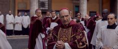 a group of men in red and white robes standing next to each other on the street