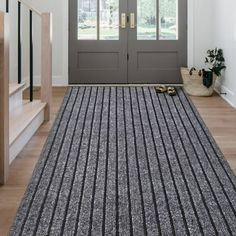 a large rug is on the floor in front of a double doored entryway