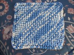 a blue and white crocheted square sitting on top of a couch