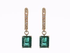 An immaculate pair of emeralds and diamond latch back earrings. Handcrafted in solid 14K yellow gold, these earrings feature two vivacious natural emerald cuts that are prong set and dropdown. Each emerald displays incredible color and clarity. Round diamonds accent the earrings. A latch back system is used in these earrings, they are secure and easy to manipulate. Earring Settings: Prong Set Gold Purity: 14K Yellow Gold Main Stone: Emerald Shape: Emerald Cut Luster: Excellent-Very Good Color: G Formal Yellow Gold Diamond And Emerald Earrings, Elegant Yellow Gold Emerald Hoop Earrings, Elegant Emerald Yellow Gold Hoop Earrings, Classic Emerald Dangle Jewelry, Gold Emerald Cut Earrings With Diamond Accents, Formal Emerald Earrings With Prong Setting, Emerald Cut Gold Earrings With Diamond Accents, Classic Emerald Drop Diamond Earrings, Classic Emerald Drop Earrings