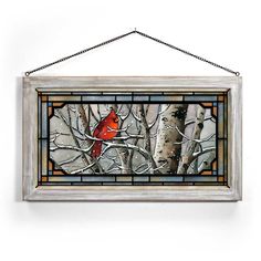 a stained glass window with a cardinal sitting on a branch in front of birch trees