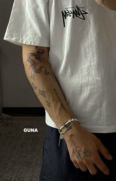 a man with tattoos on his arm wearing a white shirt