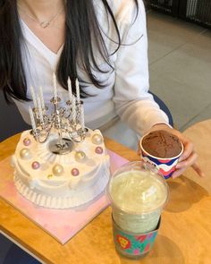 a woman sitting at a table with a cake and ice cream