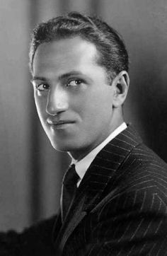 an old photo of a man in a suit and tie looking at the camera with a serious look on his face