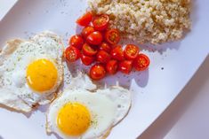 two eggs, tomatoes and rice on a plate