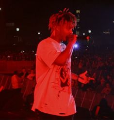 a man with dreadlocks standing in front of an audience