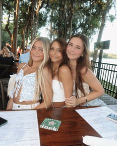 three beautiful young women sitting at a table together