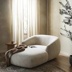 a chair sitting in front of a window next to a potted plant