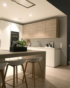 a kitchen with two stools next to a counter