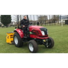 a man riding on the back of a red tractor