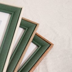 three framed pictures sitting next to each other on top of a white tablecloth covered floor