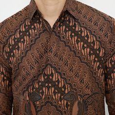 a man wearing a brown shirt with an intricate pattern