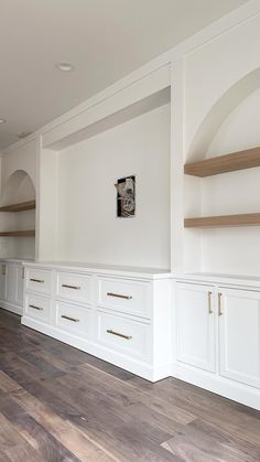 an empty room with white cabinets and wood flooring on the walls is pictured in this image