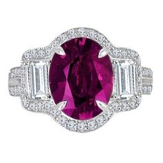 This exquisite ring, features a captivating 2.84 carat oval cut raspberry garnet at its heart. This rich, velvety gemstone is complemented by two elegantly tapered baguettes on either side, adding a touch of sophistication to the design. Surrounding this stunning trio is a glistening border of round white diamonds, creating a dazzling halo that catches the light from every angle. But the beauty doesn't stop there – a trail of these brilliant diamonds continues down the sides of the ring, enhancing its overall elegance and ensuring that your hand will always be the center of attention. This ring is a true masterpiece, a symbol of both timeless beauty and modern refinement. It's the perfect choice for those who appreciate the finer things in life. Total garnet weight 2.84 carats Total diamon Ruby Rings, Tsavorite Garnet, Diamond Fashion Rings, White Diamond Ring, Golden Ring, Garnet Ring, Pretty Rings, Garnet Rings, Diamond Fashion