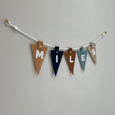 a bunting banner with the word miles hanging from it's side on a wall