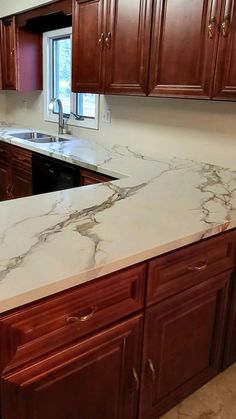 a kitchen with marble counter tops and wooden cabinets