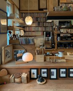 a room with many books on the shelves and pictures hanging from the ceiling in front of it