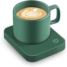 a cup of coffee sitting on top of a green coaster