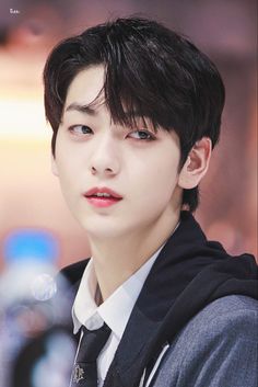 a young man with black hair wearing a white shirt and tie