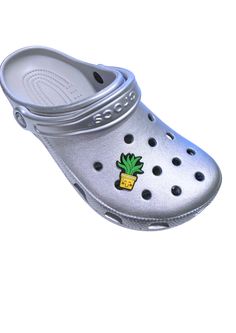 a pair of silver shoes with a pineapple on the front and bottom, all in plastic clogs