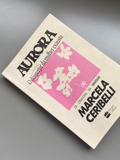 the front cover of aurora magazine, with pink and white flowers on it's back