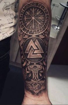 a man's arm with a clock and compass tattoo on the left side of his arm