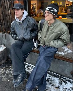 two young men sitting next to each other on a bench