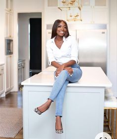 a woman sitting on top of a kitchen counter