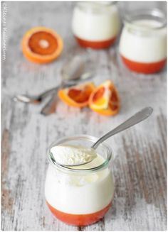 an orange and yogurt dessert in a jar with spoons on the side