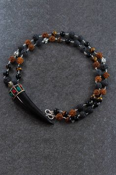 Talisman 108 beads mala is a combination of a black onyx Tibetan horn amulet inlaid with coral and turquoise, strung on a sterling silver wire featuring onyx, tigers eye and black onyx beads, to create this powerful Mala Beads prayer necklace for men. It will help you overcome obstacles and enhance success in all new endeavors and you will feel your protection circles increase, and negativity around you decrease with this strong accessory by your side. 108 Power Beads Mala Activated 8mm Rudraksh Black Round Beads Jewelry For Rituals, Spiritual Black Beaded Necklace For Festival, Artisan Black Gemstone Beads, Hand-strung Black Beaded Necklaces For Festivals, Black Hand-strung Beaded Necklaces For Festivals, Black Hand-strung Beaded Necklace For Festivals, Festival Hand-strung Black Beaded Necklaces, Festival Black Hand-strung Beaded Necklaces, Artisan Black Necklace With 108 Beads