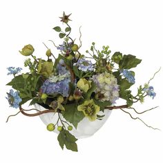 a white vase filled with lots of flowers and greenery on top of a table