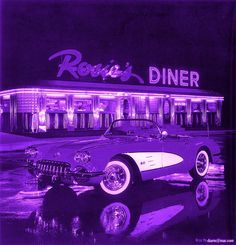 an old car is parked in front of a diner with neon lights on the building