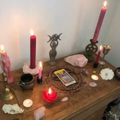 a wooden table topped with lots of candles and other items on top of it's surface