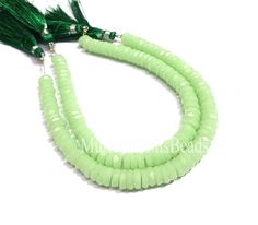 green beads with tassels on a white background