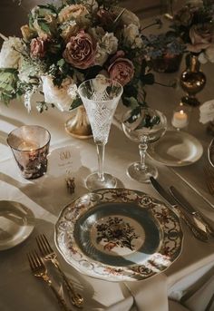 the table is set with flowers and silverware