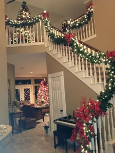 christmas decorations on the banisters and stairs in a home decorated with red, white and green garland