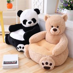 two stuffed animals sitting on chairs in front of a window, one is black and the other is white