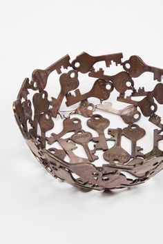 a metal bowl filled with lots of different types of key shapes on it's sides