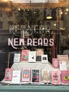 there is a display in the window with books on it that are all pink and white