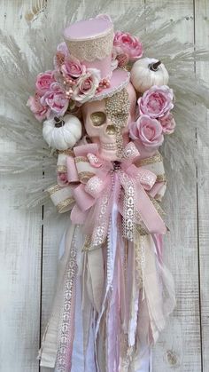 a skull wearing a pink top hat with flowers on it's head and ribbons around its neck